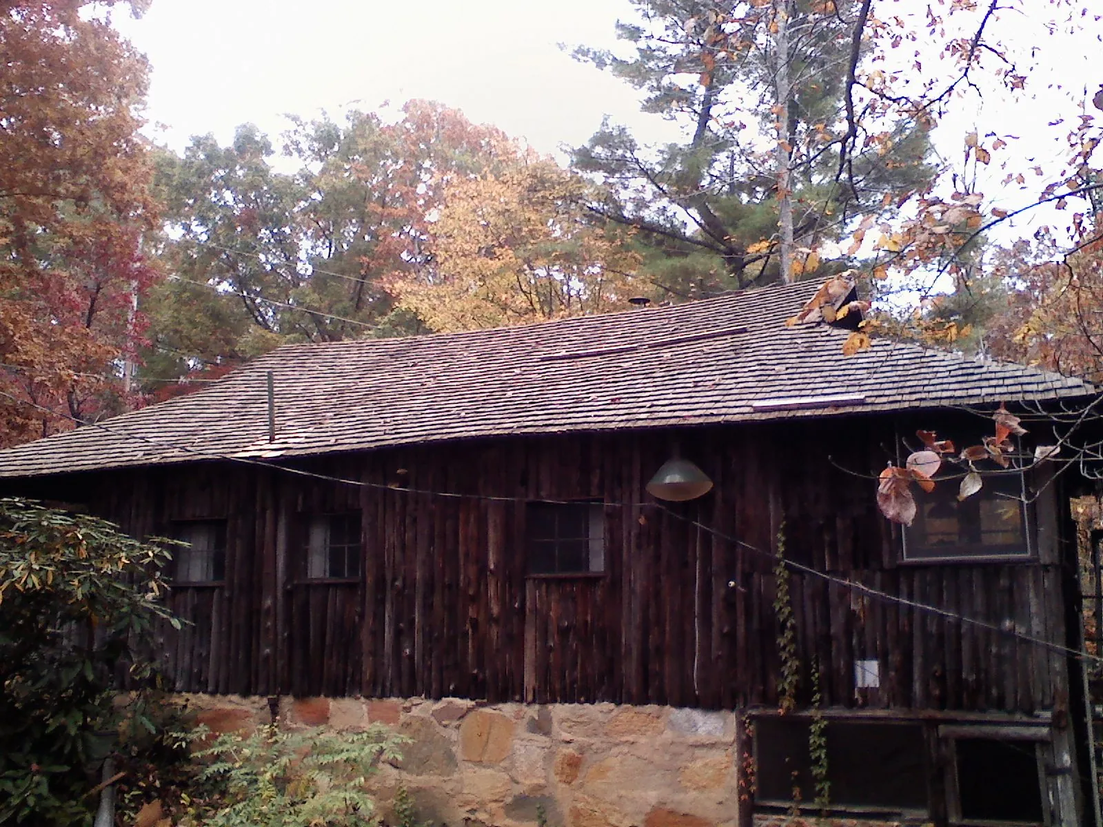 Weathered wood shake roof on a rustic board sided cabin in Andover